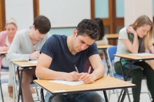 Jovenes realizando examen en un aula