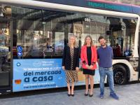 La concejala de Comercio, Lidia López junto al logotipo del Mercado en los autobuses