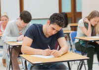 Jovenes realizando examen en un aula