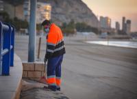 Operario realizando la limpieza de la playa del Postiguet