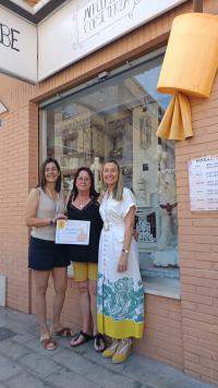 Imagen de la concejala de Comercio, Lidia Lópe, entregando el primer premio de Escaparates a Mercería Mabe