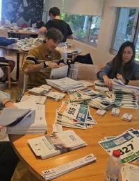 Imagen de los voluntarios que  han comenzado a ensobrar los números de los corredores