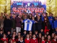 Imagen del alcalde de Alicante, Luis Barcala, junto a los integrantes de la primera plantilla del Hércules y al coro ‘Voces Blancas’, del cole...