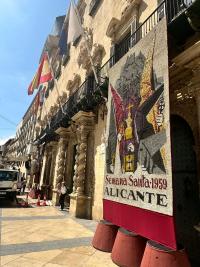 Imagen dela instalación de los tapices florales alusivos a los carteles de 2026 y 1959 en el Ayuntamiento de Alicante